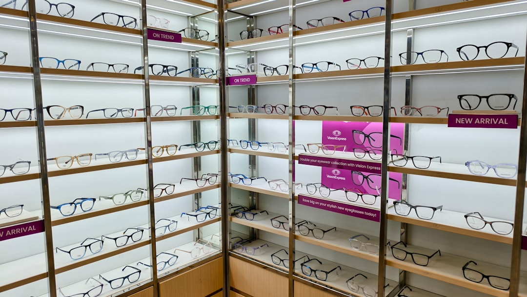 Bir optik mağazasında çeşitli gözlük modellerinin sergilendiği ve yerel üreticilerin öne çıkan ürünlerinin göründüğü bir iç mekan görüntüsü